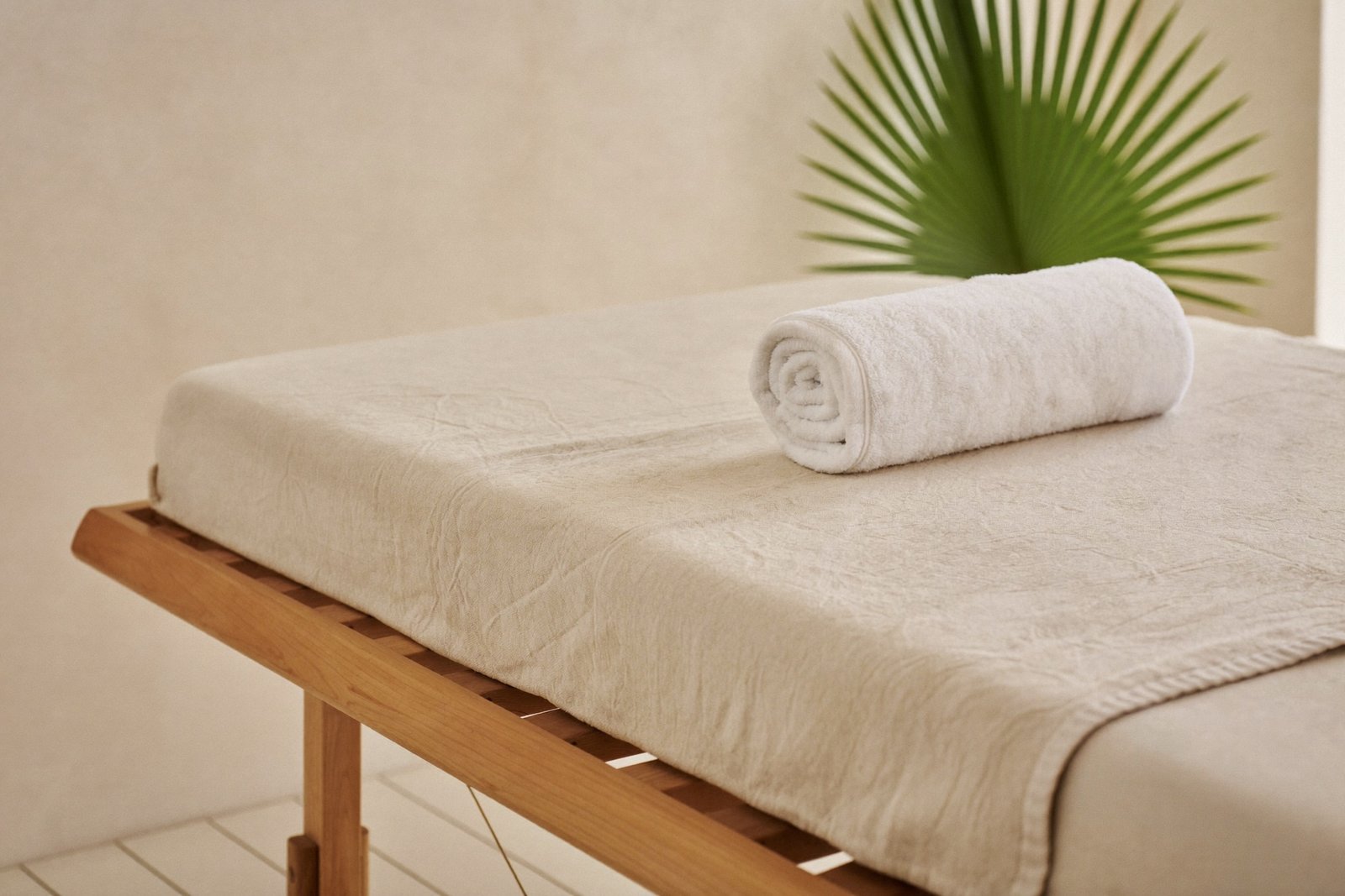 Spa massage bed with rolled towels and frangipani