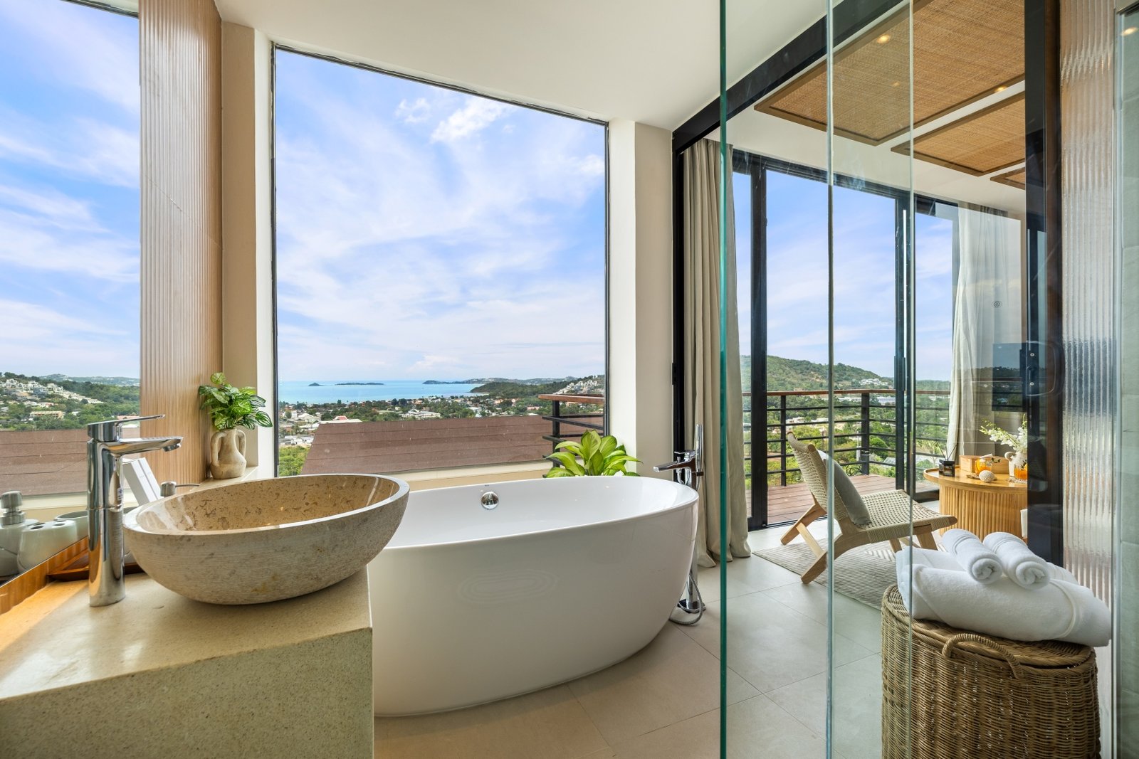 Freestanding bathtub and stone basin facing the sea